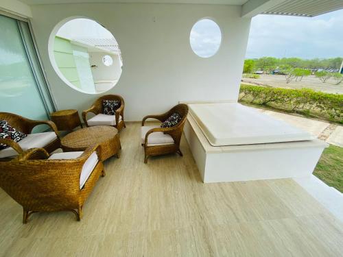 a room with a bed and chairs and a mirror at Cabaña frente al mar in Tubará
