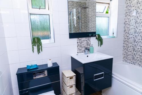 a bathroom with a blue cabinet and a sink at Entire 3Bed in Greater Manchester with Fast Wi-Fi, Garden & Free Parking in Little Hulton