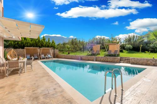 a swimming pool with a patio and a table and chairs at Allas Villa Heated Pool in Chania