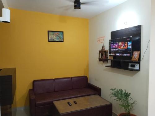 AyodhyaThe Sunrise Ayodhya Guest House的带沙发和平板电视的等候室