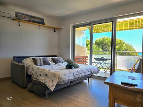 une chambre avec un lit et un balcon avec une table dans l'établissement Les Embruns - Super Vue mer, refait à neuf avec parking privée à La Ciotat - BY AURAconciergerie, à La Ciotat