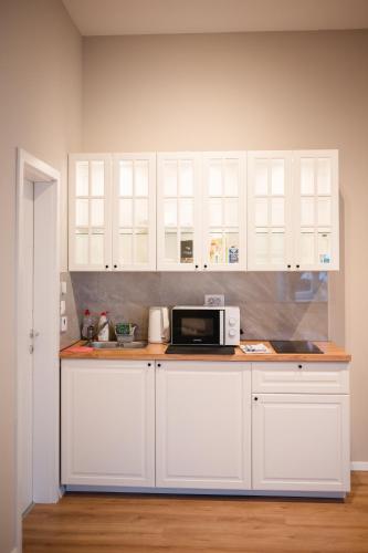a kitchen with white cabinets and a microwave at Kaptol 6 in Zagreb