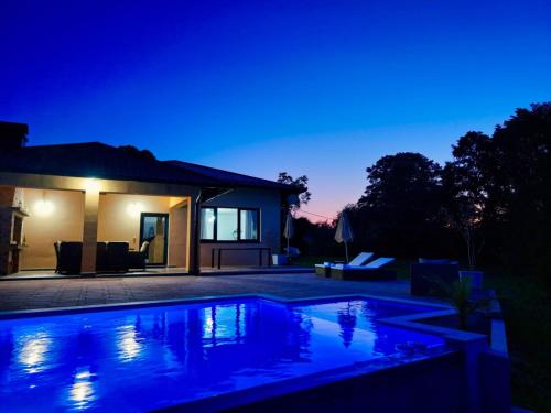 a house with a swimming pool at night at Vikendica-Villa Belvedere Srebrenik in Srebrenik