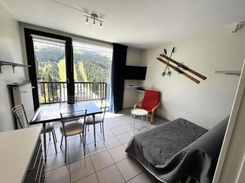 Cette chambre dispose d'une table, de chaises et d'un balcon. dans l'établissement Résidence Vega - Studio rénové · Proche des pistes et des commerces · Balcon MAE-6223, à Magland