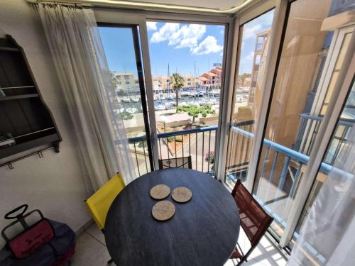 - une table dans une chambre avec une grande fenêtre dans l'établissement Résidence Le Castellet - 2 Pièces 4 couchages PORT LEUCATE. Réf: 5CAS_97B MAE-6263, à Leucate