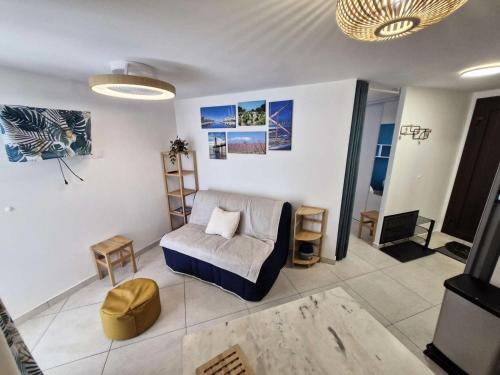 un salon avec un canapé et une chaise dans l'établissement Résidence Le Castellet - 2 Pièces 4 couchages PORT LEUCATE. Réf: 5CAS_97B MAE-6263, à Leucate