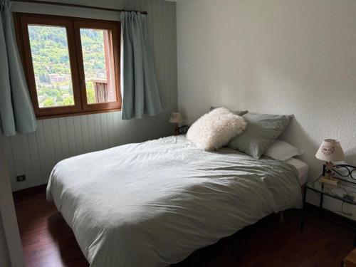 - un lit blanc dans une chambre avec fenêtre dans l'établissement 3 Bed Apartment with Private Terrace, Communal Pool, Mont Blanc Views, à Saint-Gervais-les-Bains