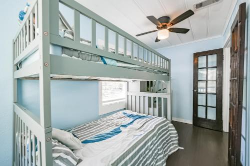 a bedroom with bunk beds and a ceiling fan at Beach lovers dream come true walking distance to the sandy shores in Galveston