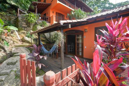 an orange house with a fence in front of it at Casa da Ilha & SPA in Abraão