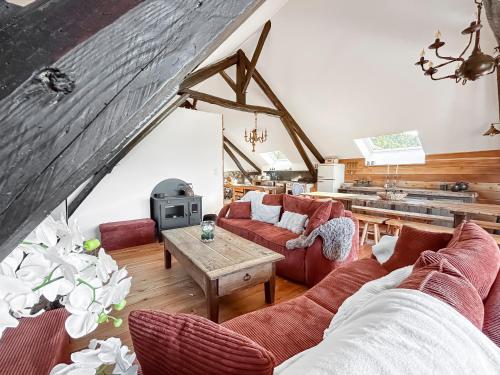 un salon avec des canapés rouges et une table dans l'établissement Charme Rustique et moderne entre Alpes & Provence, à Venterol