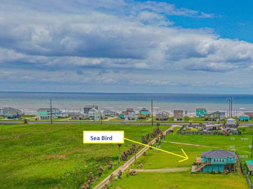 an aerial view of a beach with a sea bird sign at Fly Away to Sea Bird Life is Better in Flip-Flops in Galveston