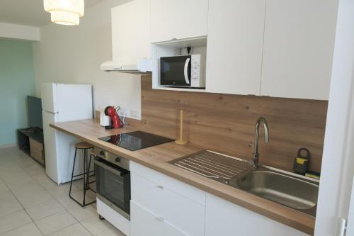 a kitchen with a sink and a microwave at La Terrasse - Centre-ville - Parking - Netflix in Valence