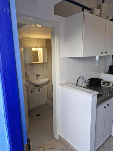 a small white kitchen with a sink and a counter at Thalias apartments in Kómi