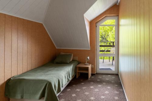 a small bedroom with a bed and a window at Ema in Palanga
