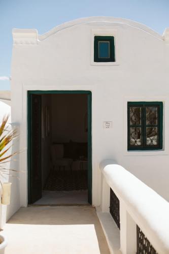 a stairway leading to a door in a white building at Dar Naël in Houmt Souk