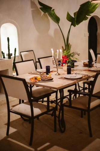 a dining room table with food and candles on it at Dar Naël in Houmt Souk