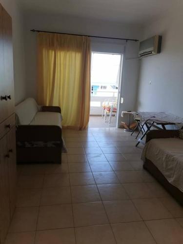 una camera con letto, divano e finestra di Markou Mpotsari 19 & Hras, Perigiali , Korinthias a Kórinthos