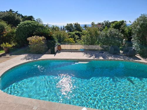 une piscine avec de l'eau bleue dans une cour dans l'établissement Villa Roxane, à Vallauris