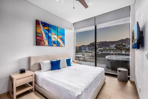 a bedroom with a bed and a large window at Cabo Marina Luxury Condo Jacuzzi & Terrace in Cabo San Lucas