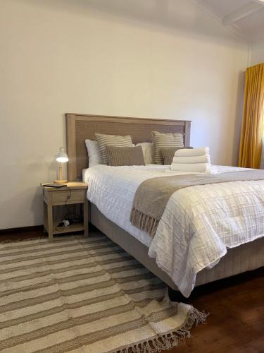 a bedroom with a large bed and a night stand at Honeydew Cozy Cabin in Vosburg