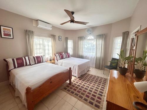 a bedroom with two beds and a ceiling fan at 5-Bed Villa with pool in Runaway Bay Jamaica in Cardiff Hall