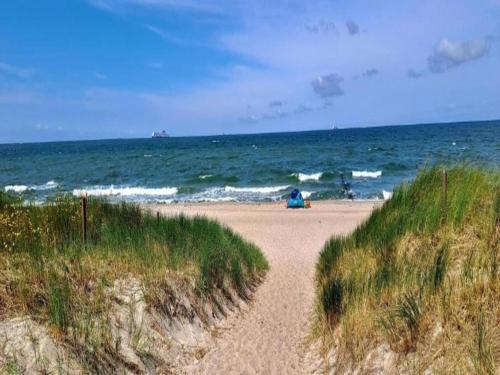 a sandy path leading to the ocean on a beach at Wohnung nahe Ostsee Graal Müritz Strand in Rövershagen