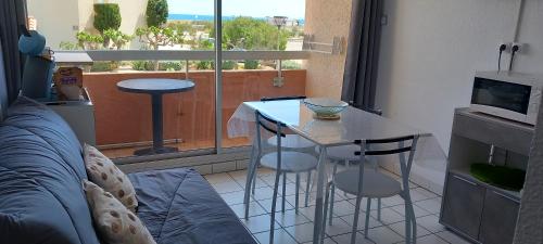 - un salon avec une table et deux tabourets devant une fenêtre dans l'établissement Studio avec vue sur mer , plage à 150 m et proche des commerces, au Barcarès