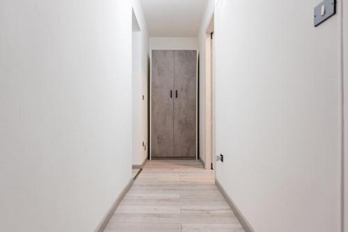 an empty corridor with a door in a white hallway at La Quiete del Pero Fiorito Villa in the Langhe in Monastero Bormida