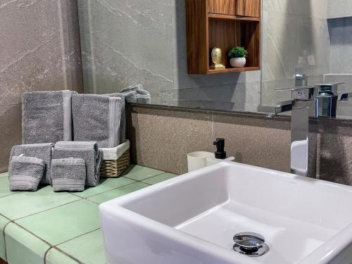 a bathroom with a sink and towels on a counter at Sunrise 2BR Apt Steps from the Beach with Pool View in Holbox Island