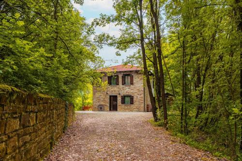 a stone house in the middle of a forest at La Quiete del Pero Fiorito Villa in the Langhe in Monastero Bormida