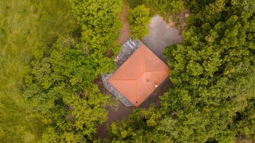 an aerial view of a red building in the middle of a forest at La Quiete del Pero Fiorito Villa in the Langhe in Monastero Bormida