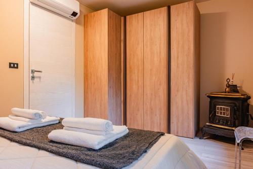 a bedroom with towels on a bed with a fireplace at La Quiete del Pero Fiorito Villa in the Langhe in Monastero Bormida