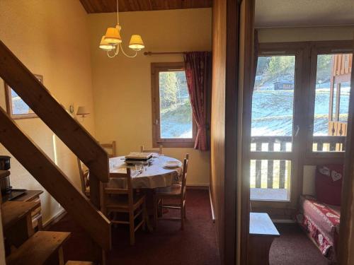une salle à manger avec une table et deux fenêtres dans l'établissement Résidence Lauziere Dessous - La Lauzière-Dessous 47 - Appartement agréable au pied des pistes MAE-7451, à Valmorel