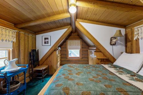 1 dormitorio en una cabaña de madera con 1 cama y 1 silla en Authentic Maine Log Cabin, en Greenville