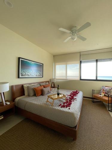 a bedroom with a bed and a ceiling fan at Sunset 2BR Apartment Steps from the Beach with Ocean View in Holbox Island
