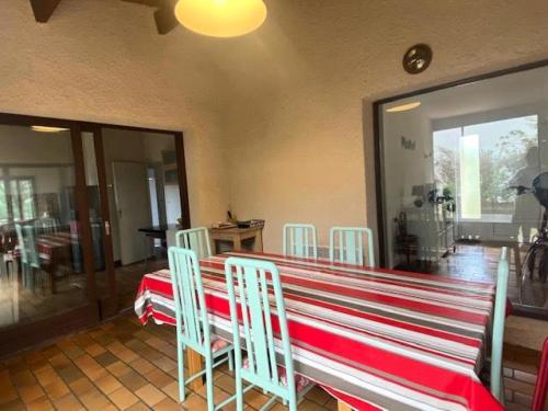 une salle à manger avec une table et des chaises rouges et blanches dans l'établissement Résidence 111-montalivet - 111 - Maison spacieuse en plein centre de Montalivet MAE-7091, à Vendays-Montalivet