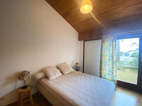 une chambre avec un lit blanc avec une fenêtre dans l'établissement Résidence 111-montalivet - 111 - Maison spacieuse en plein centre de Montalivet MAE-7091, à Vendays-Montalivet