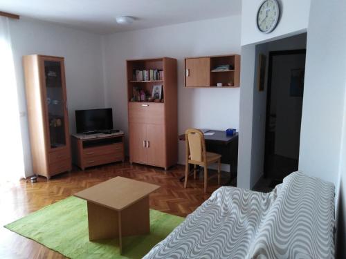 a room with a bed and a desk and a table at Apartman Tomas in Povile