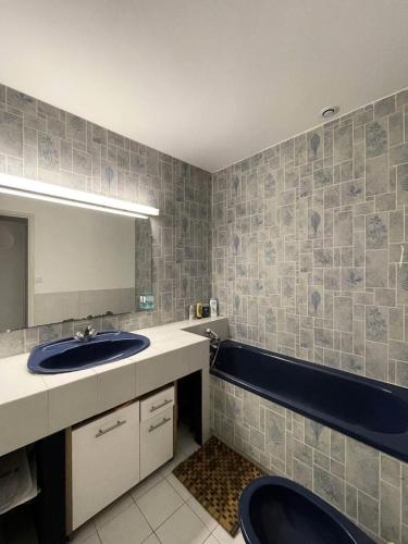 une salle de bain avec un lavabo, un miroir et une baignoire dans l'établissement Résidence 112-montalivet - 112 - Jolie maison en plein cœur de la station balnéaire de Montalivet MAE-7111, à Vendays-Montalivet