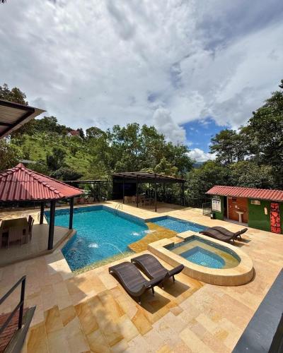 a swimming pool with lounge chairs next to a house at Eco Boutique-Sierra in La Vega