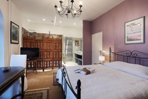 une chambre avec un lit, un bureau et une télévision dans l'établissement Le Temps Suspendu - Charming 4-stars house in Savoie, à Grésy-sur-Aix