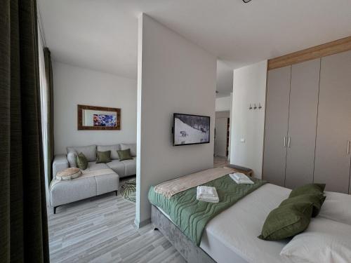 a room with two beds and a living room with a couch at Sal y Sol in Bar