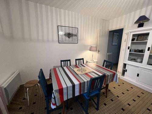 une table à manger avec des chaises et un tissu de table rayé dans l'établissement Résidence 117-montalivet - 117 - Maison avec joli jardin proche du centre de Montalivet MAE-7101, à Vendays-Montalivet