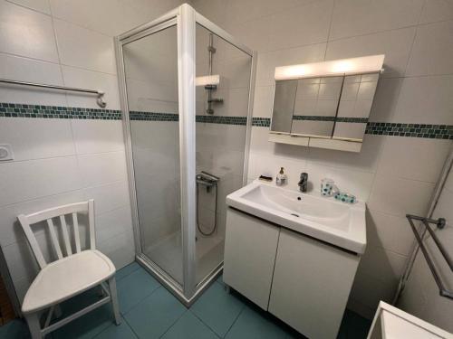 une salle de bain blanche avec une douche et un lavabo dans l'établissement Résidence 117-montalivet - 117 - Maison avec joli jardin proche du centre de Montalivet MAE-7101, à Vendays-Montalivet
