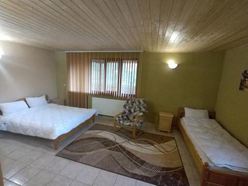 a bedroom with two beds and a chair in it at Къща за гости Кършеви in Elena