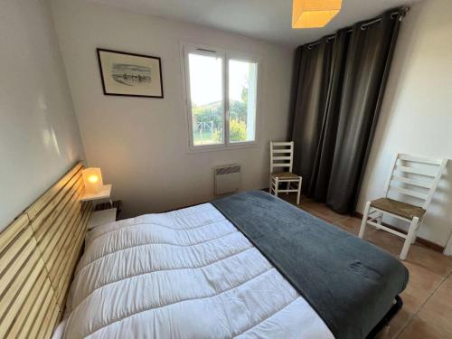 une chambre avec un lit, une fenêtre et une chaise dans l'établissement Résidence 121-montalivet - 121 - Agréable maison de vacances dans Montalivet MAE-4891, à Vendays-Montalivet