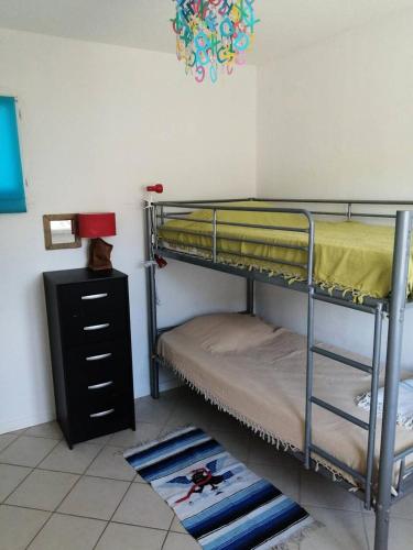 Cette chambre dispose de lits superposés avec 2 lits superposés et une commode. dans l'établissement Résidence Les Hameaux - 109- Villa dans un petit Hameau avec piscine collective à Vendays MAE-7171, à Vendays-Montalivet
