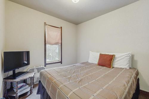 a bedroom with a bed and a tv and a window at Red Cricket 22 in Sandpoint