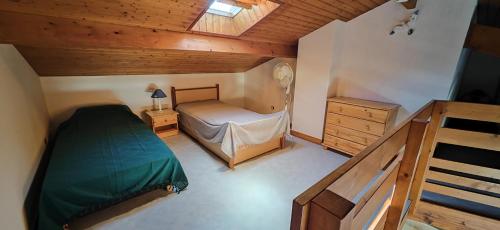 - une petite chambre avec un lit et un plafond en bois dans l'établissement Logement à Saint-Palais-sur-Mer, à Saint-Palais-sur-Mer