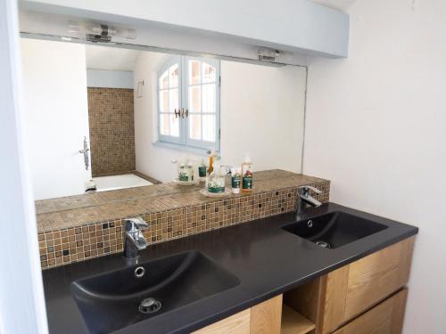 une salle de bain avec deux lavabos et un miroir dans l'établissement Maison Landaise proche plage& centre-ville !, à Seignosse